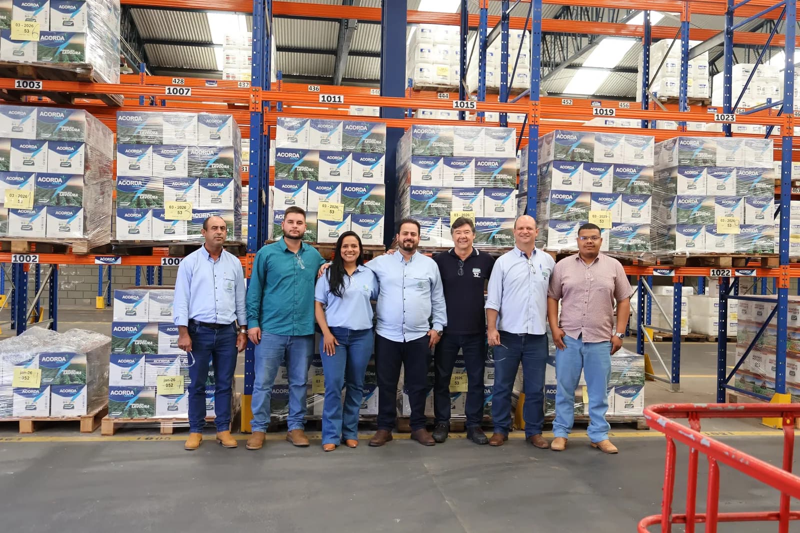 Grupo da Juma Experience no galpão de produção, entre pallets de Acorda Ultra